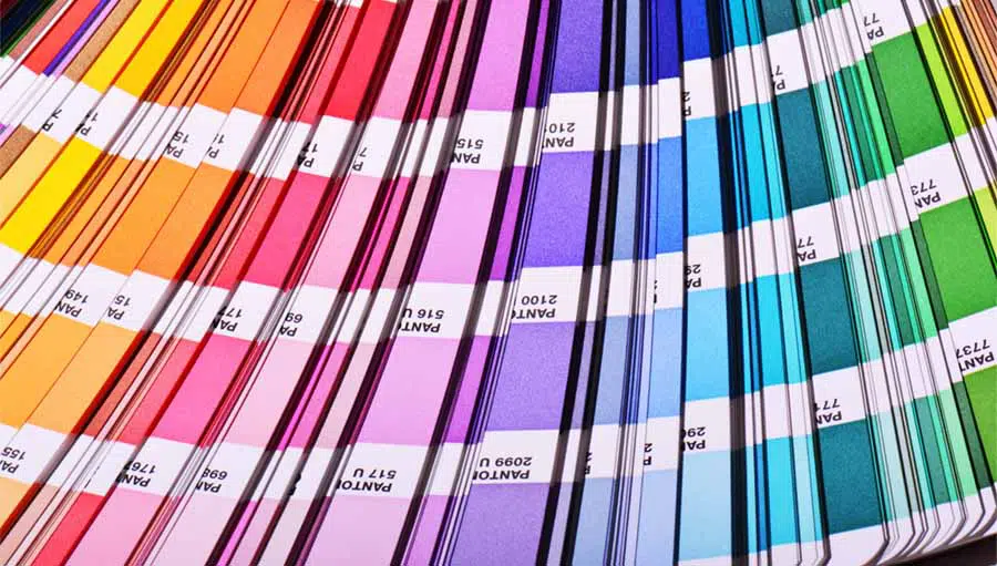 Pantone color book spread open displaying a rainbow of colors.